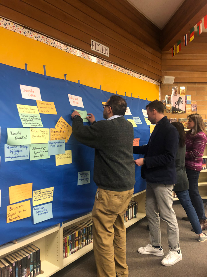A member of the public pins a piece of paper to a board