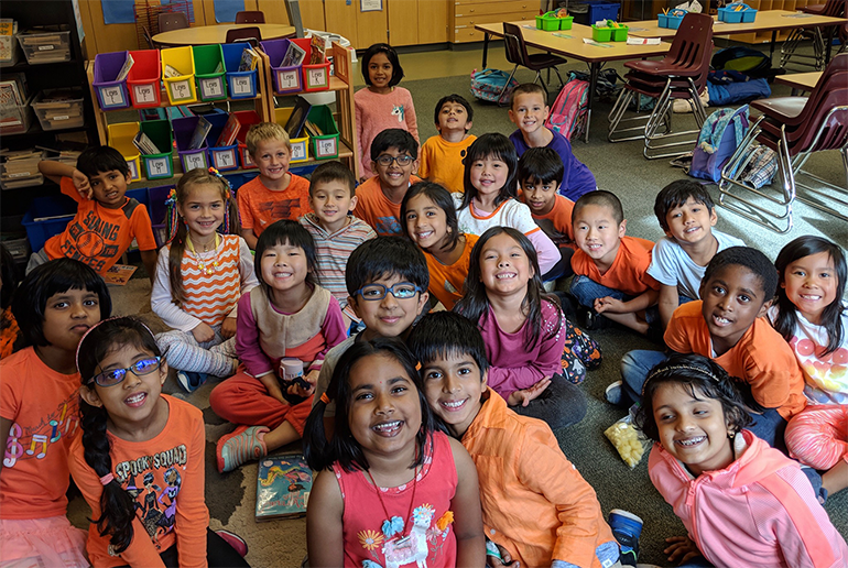 A group of students smiling in a classroom